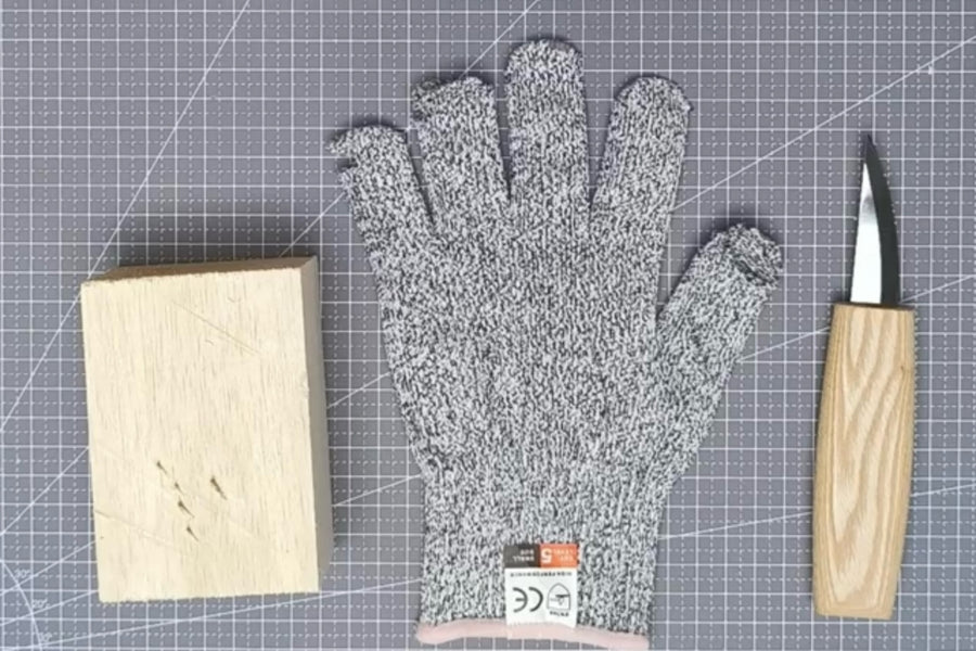 Cut-resistant glove, carving knife, and wood block on a cutting mat