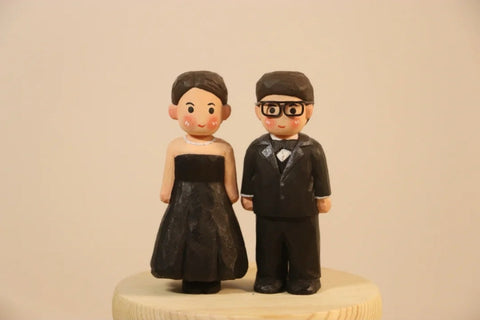 Painted couple figures in black formal outfits displayed side by side.