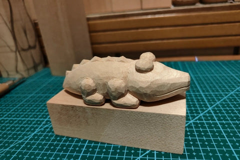 Unpainted cartoon crocodile with raised eyes and a long tail