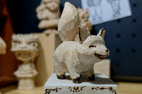 Finished small fox carving with a pointed nose and raised tail