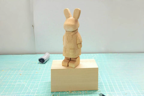 Finished Mr. Bunny carving with long ears, a coat, and two feet