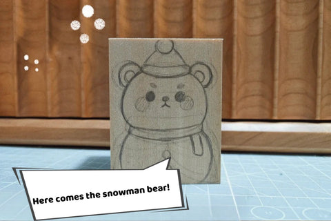 Front drawing of a snowman bear wearing a hat and scarf