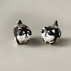 Two hand-carved wooden dog keychains side by side, highlighting the differences in their hand-painted designs