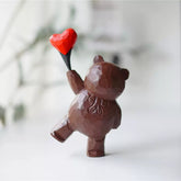 Bear figurine with heart balloon, hand-carved and painted.
