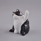 Black and white cat figurine with raised paw