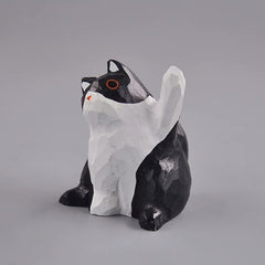Black and white cat figurine with raised paw