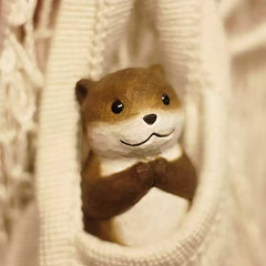 Chibi otter figurine peeking through knit fabric