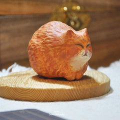 Handmade custom cat statue in a curled loaf pose, highlighting the cat’s chubby charm and unique facial features.