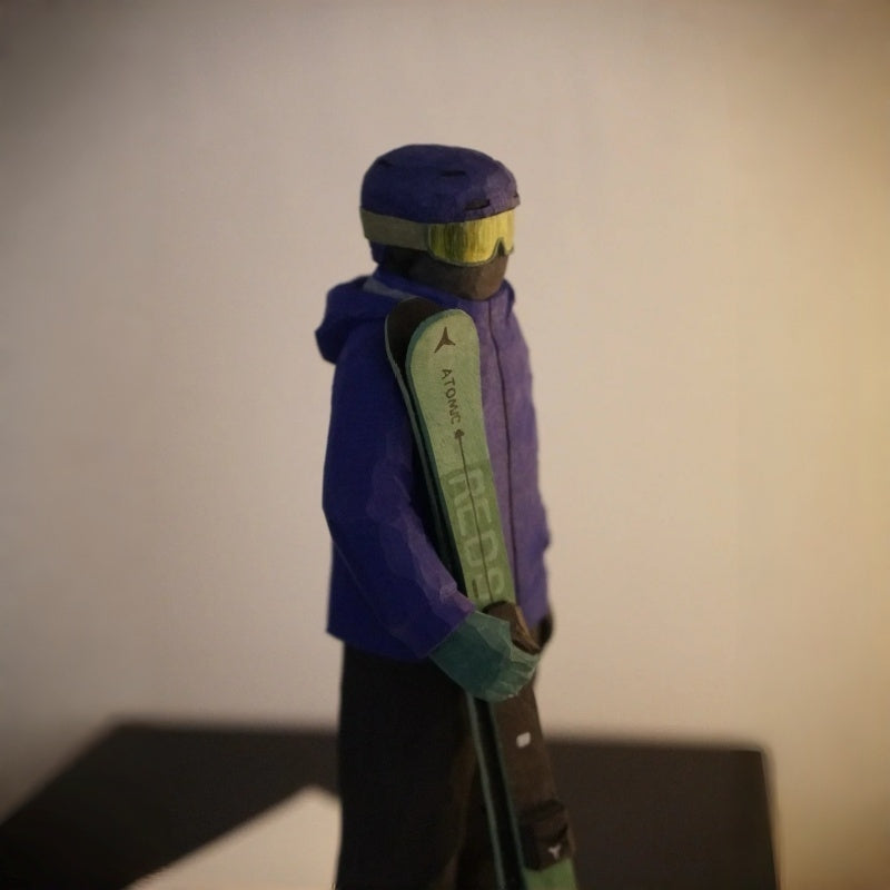 Angled view of custom ski figurine with skis, hand carved wooden sculpture made from photo