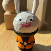 Hand-carved jester bunny figurine with playful expression and festive costume.