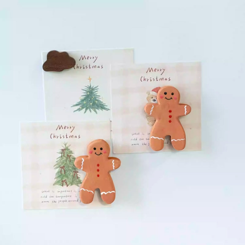 Two gingerbread man magnets and an additional brown magnet holding Christmas cards