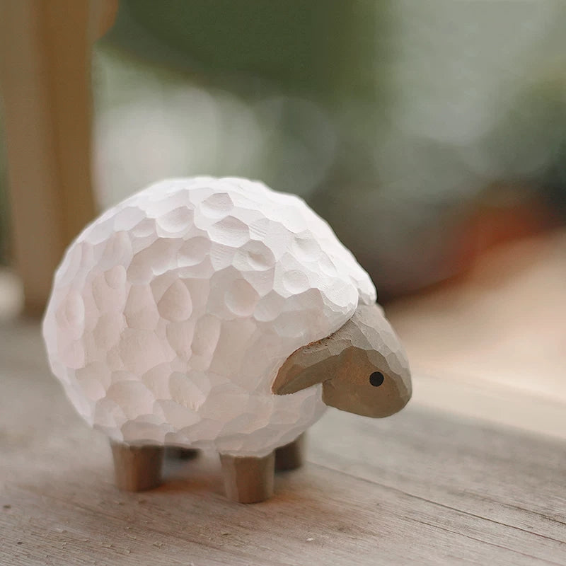 Side view of hand carved lamb figurine on wooden surface