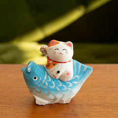 Lucky cat figurine on blue koi close up