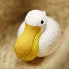 Pelican figurine viewed from the front with a large yellow bill