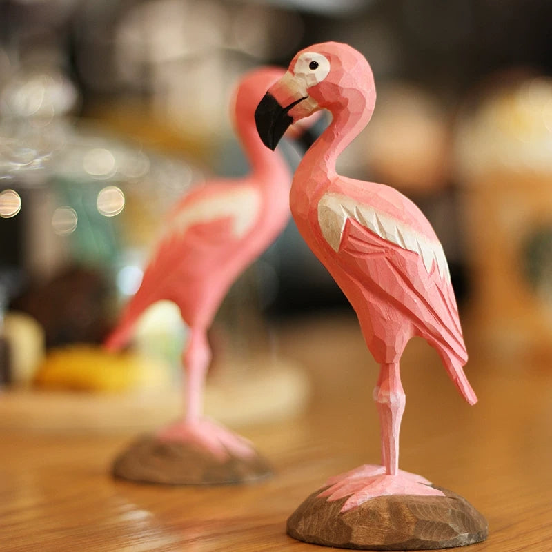 Wooden flamingo figurine displayed on its carved base