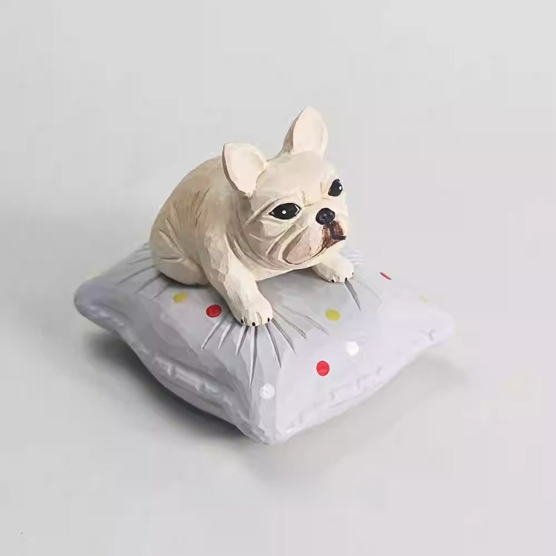 Wooden French bulldog figurine viewed from the front on its cushion