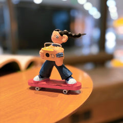 Hand-carved skater girl figurine riding a red skateboard with boombox, side angle