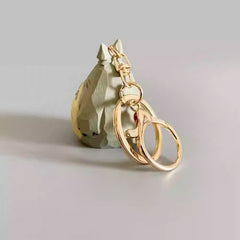 Back view of the wooden Totoro keychain showing hand-carved texture and gold hardware.