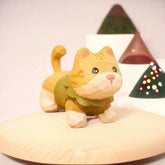 Yellow tabby kitten figurine in green sweater