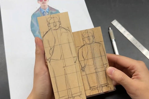 Two wooden blocks with the same clothed figure drawn at different heights.