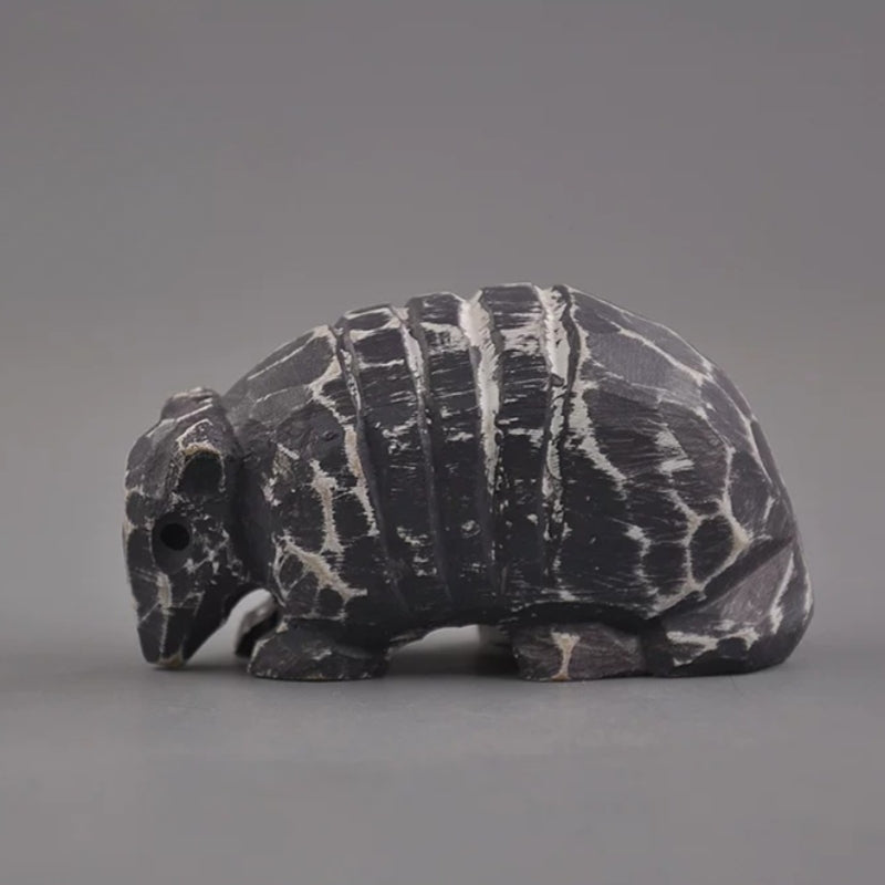 Side view of armadillo wooden figurine with charcoal and white finish