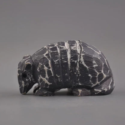 Side view of armadillo wooden figurine with charcoal and white finish