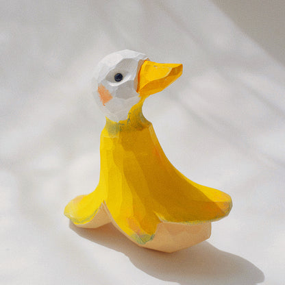Handmade wooden sculpture of a banana duck on a tabletop.