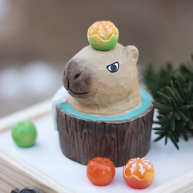 A bubble bath styled capybara figure is placed on a wooden box.