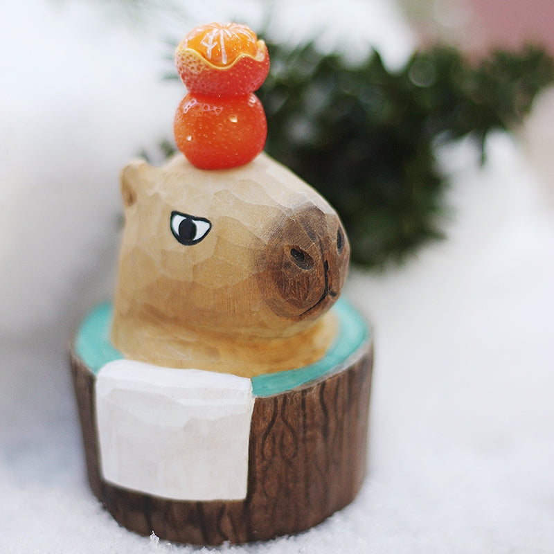 A bubble bath styled capybara figurine placed in a snowy scene.