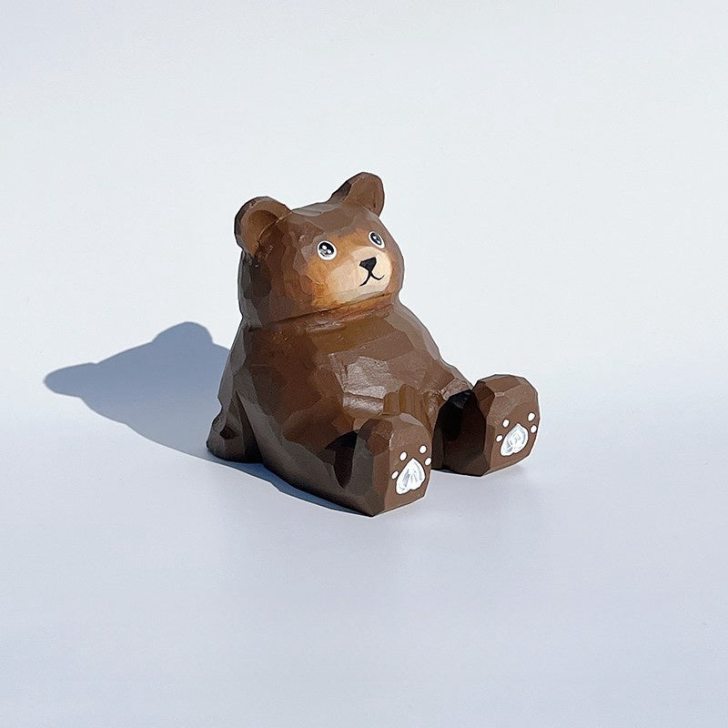 Brown bear phone holder with cartoon style carved wooden figure.