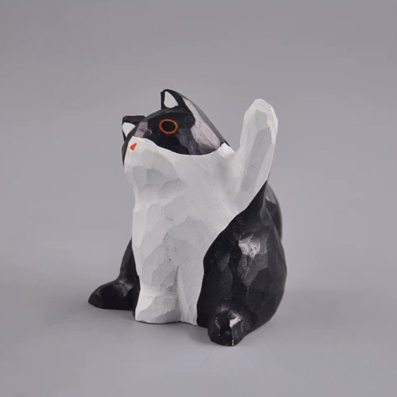 Black and white cat figurine with raised paw