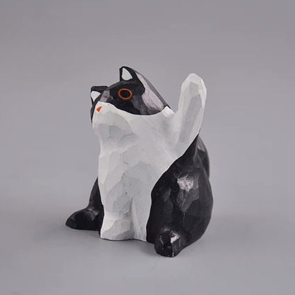 Black and white cat figurine with raised paw