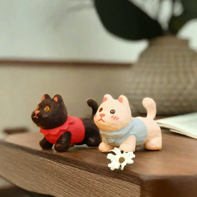 Black and white kitten figurines with sweaters