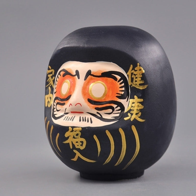 Side view of black wooden daruma doll