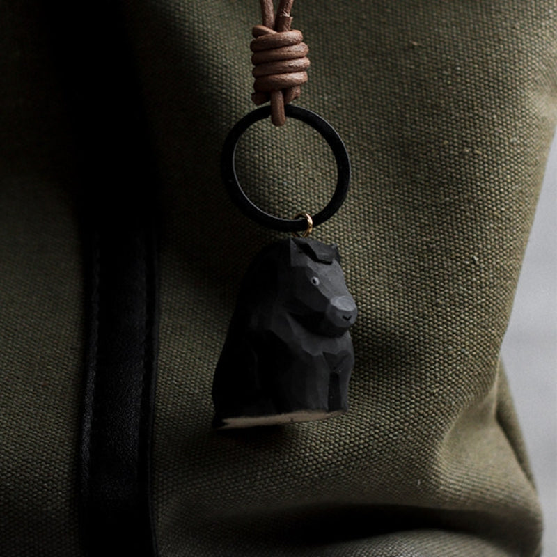 black wooden horse keychain on backpack
