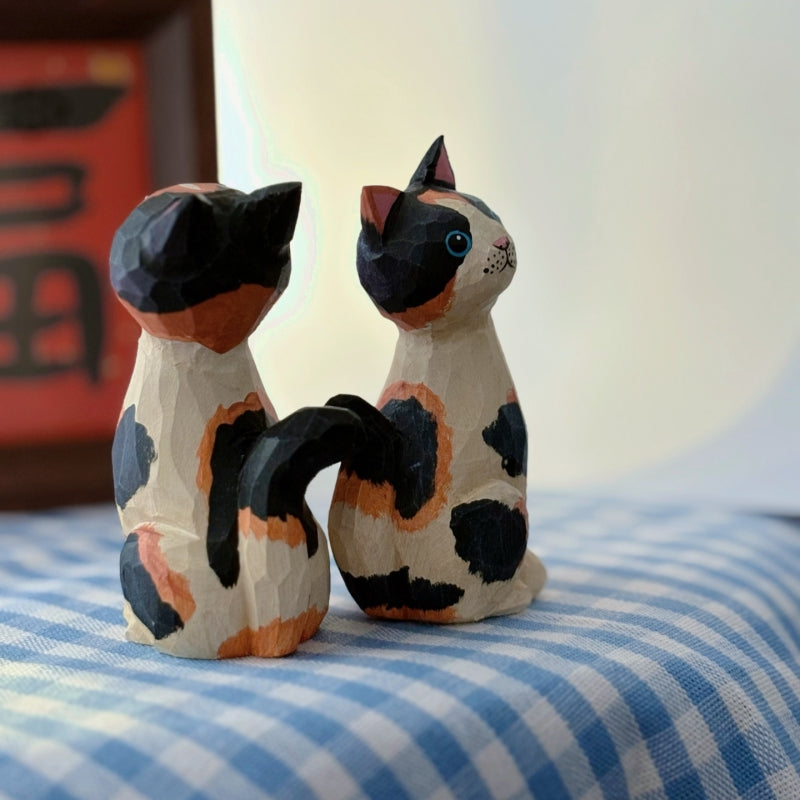 Back and side view of wooden calico cat figurine with curved tail