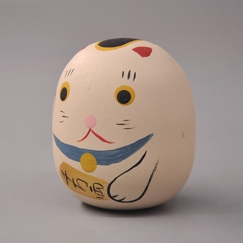Side view of cat daruma doll figurine