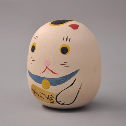 Side view of cat daruma doll figurine