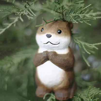 Chibi otter figurine with green cypress foliage backdrop