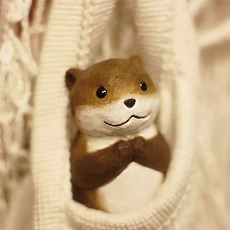 Chibi otter figurine peeking through knit fabric