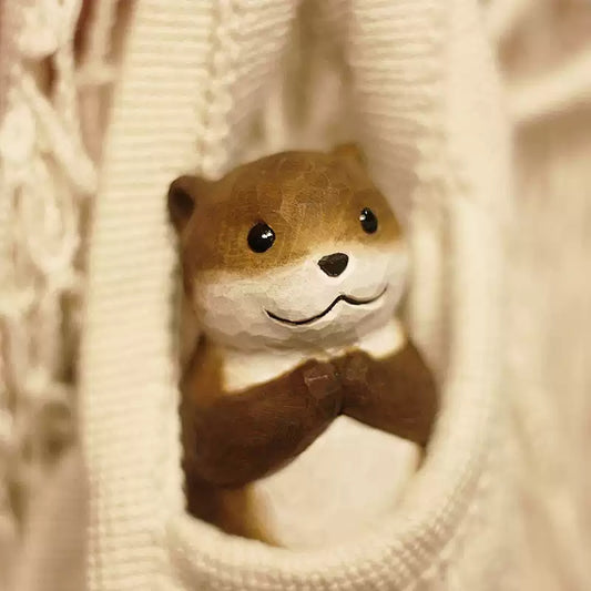 Chibi otter figurine peeking through knit fabric