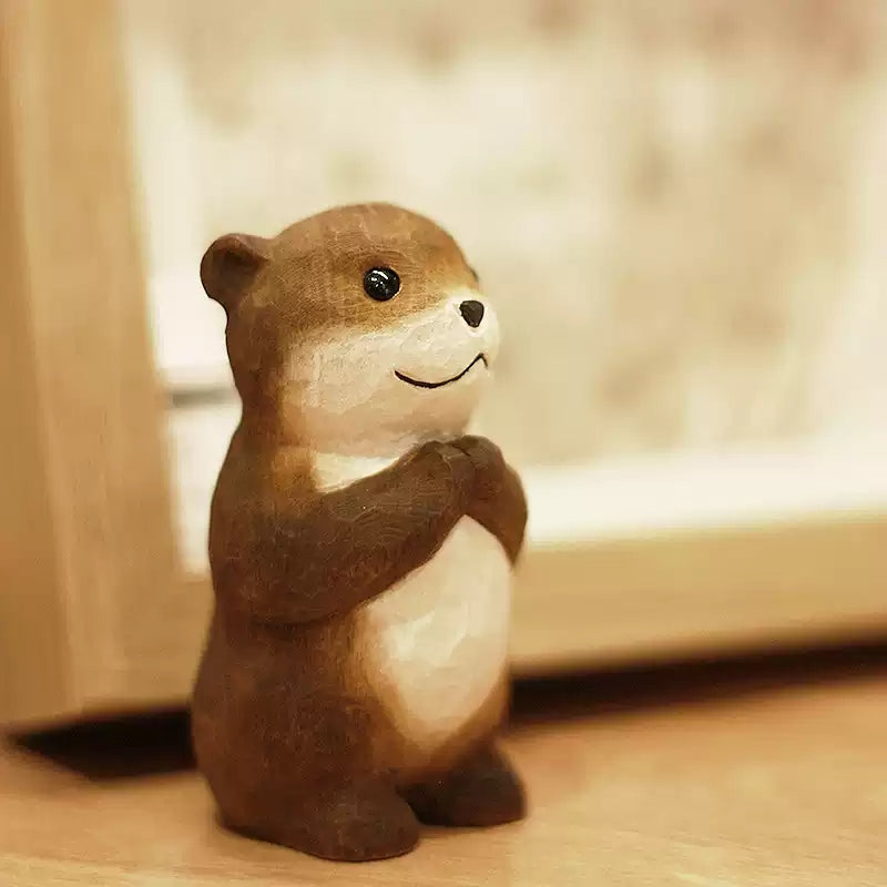 Chibi otter wooden figurine on windowsill in soft light