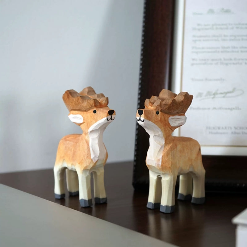 Hand-carved wooden Christmas reindeer figurines displayed as a matching pair