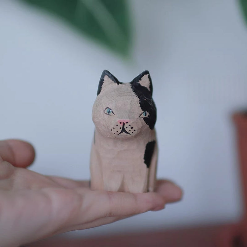 Cow patterned cat wooden figurine in hand