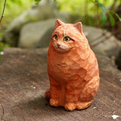 Hand-carved custom cat figurine of a sitting orange tabby, showcasing detailed wood texture and lifelike expression.