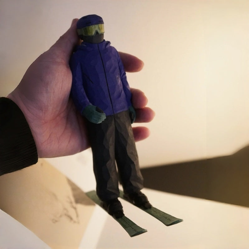Hand holding custom ski figurine to show size, personalized wooden skier sculpture