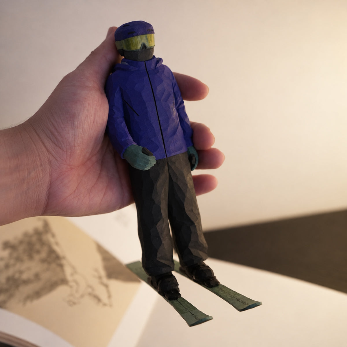 Custom ski figurine held in one hand, showing the full figure and green skis