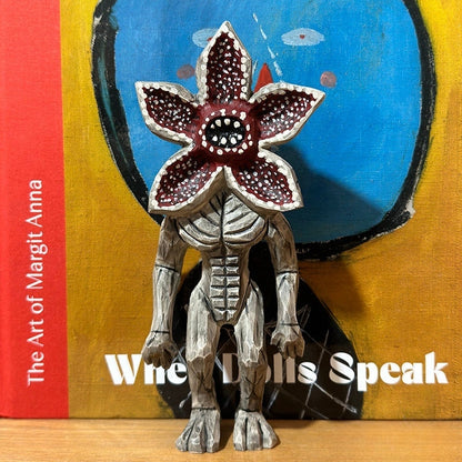 Demogorgon figure posed in front of colorful modern artwork, adding contrast to the rustic wood.