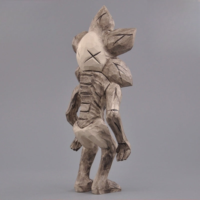 Back view of wooden Demogorgon figure showing sculpted spine and petal-shaped head.