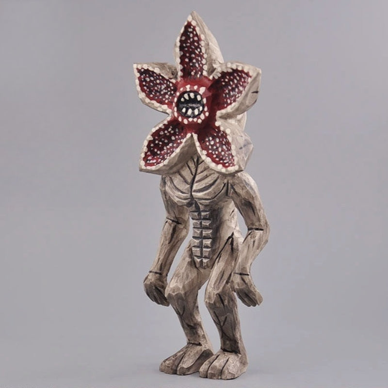 Angled side view of the Demogorgon figure, showcasing the hand-carved muscle definition and pose.